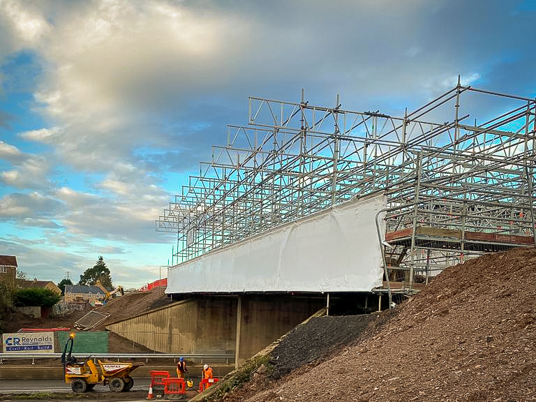 Droplift scaffold with shrinkwrap containment over live highway in Nuneaton.