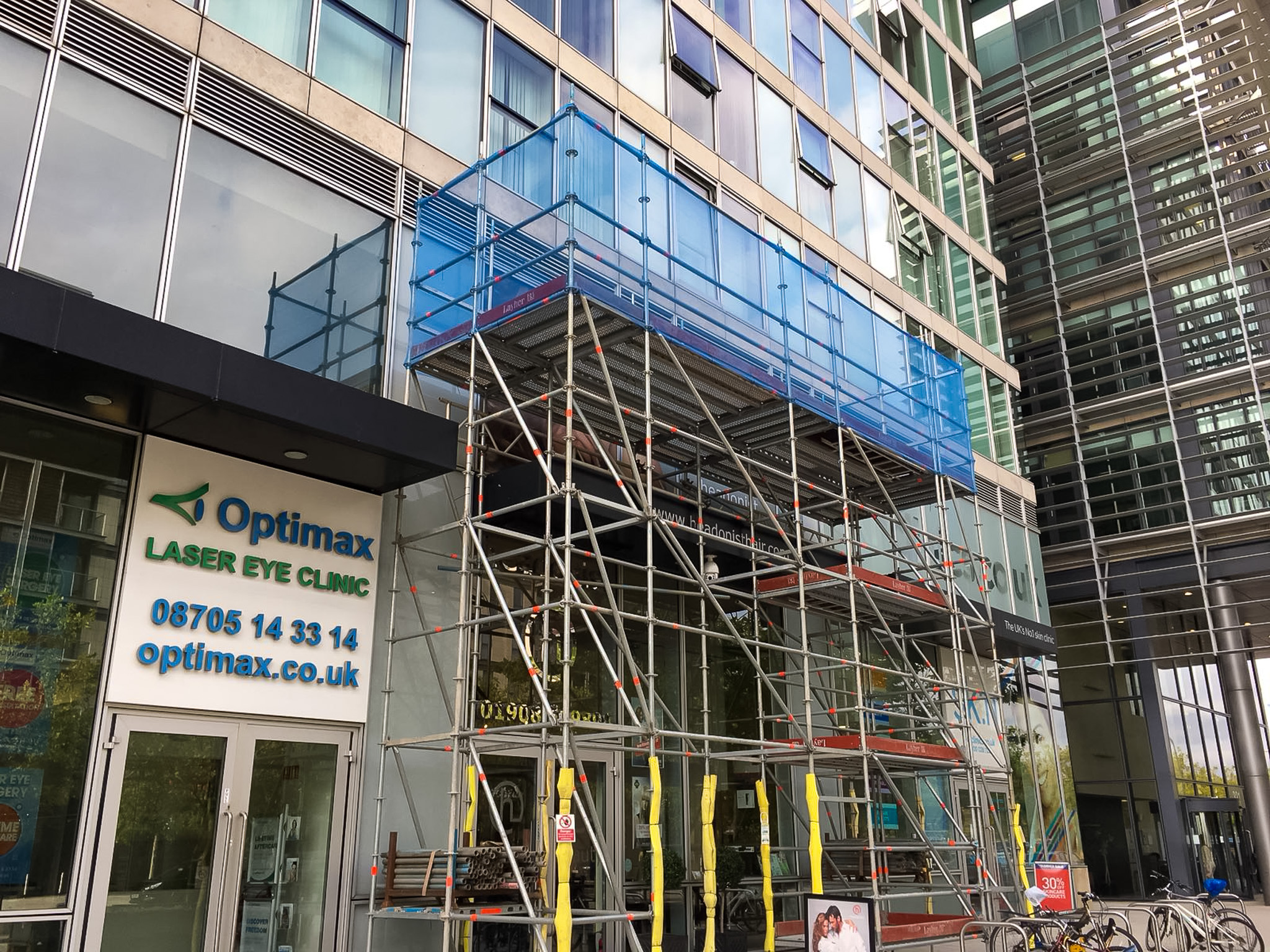 Access scaffold for maintenance to a retail unit with glass cladding.