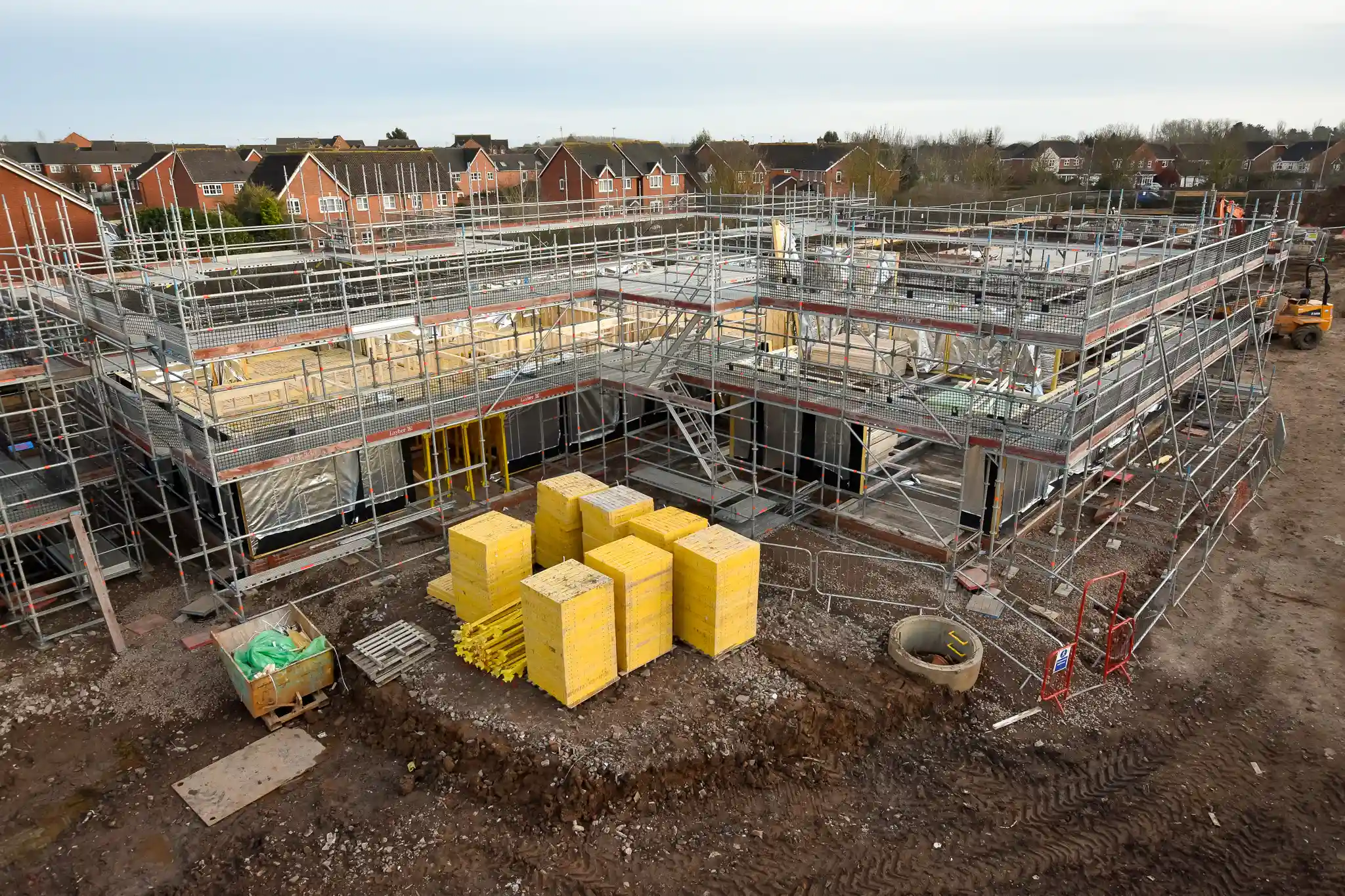 Buttressed scaffold with staircase access and internal guardrails on a timber frame construction site in Leamington Spa