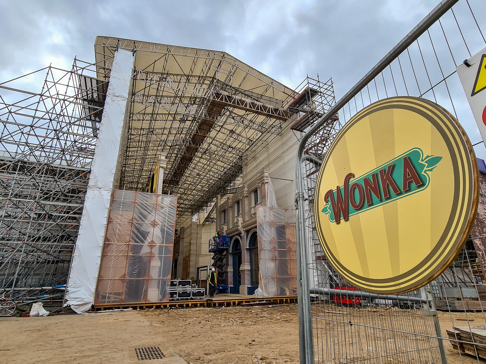 Rear entrance to the temporary building with set buildings inside and Wonka sign in the foreground